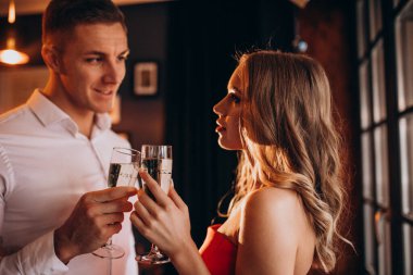 Sevgililer gününde bir restoranda şampanya içen çift.