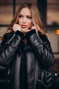 Kafenin orada gündelik giyinmiş çekici genç bir kadın.