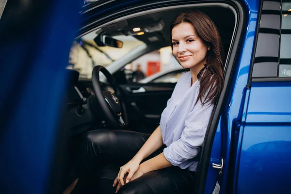 Młoda Kobieta Salonie Samochodowym Wybiera Samochód — Zdjęcie stockowe