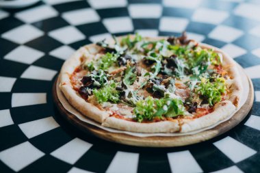 Lezzetli yuvarlak pizza, masaya yakın.