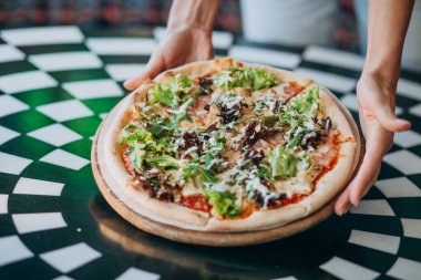 Lezzetli yuvarlak pizza, masaya yakın.