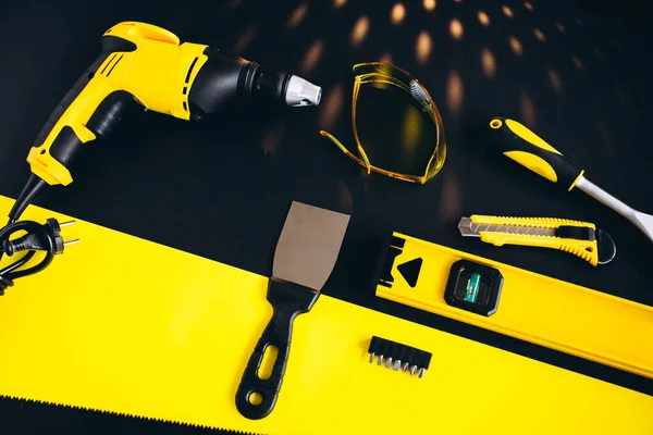 Set of yellow tools on a black and yellow background
