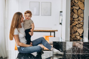 Anne ve küçük oğlu evde oynuyorlar.