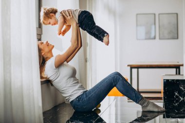 Anne ve küçük oğlu evde oynuyorlar.