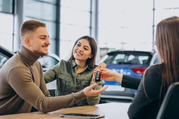 Young Couple Talking Sales Person Car Showroom — Stock Photo, Image