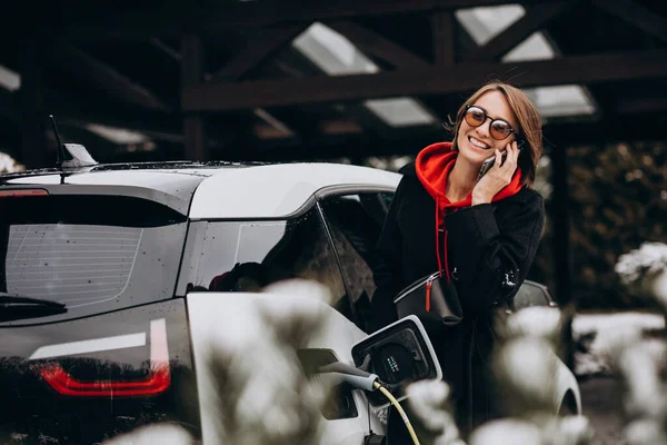 Egy Elektromos Autót Tölt Telefonon Beszél — Stock Fotó