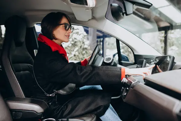 Kobieta Siedząca Samochodzie Elektrycznym Podczas Ładowania — Zdjęcie stockowe