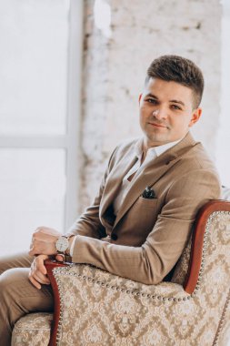 Stüdyoda şık takım elbiseli yakışıklı bir genç.