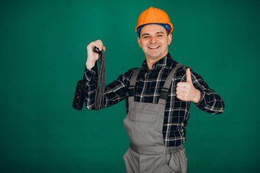 Yeşil arka planda izole edilmiş kasketli işçi.