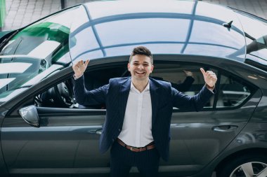 Araba fuarında genç ve yakışıklı bir iş adamı.