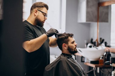 Berber dükkanında saç kesimi yapan bir müşteri.