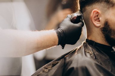 Berber dükkanında saç kesimi yapan bir müşteri.