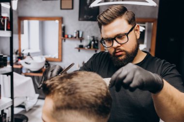 Berber dükkanında saç kesimi yapan bir müşteri.