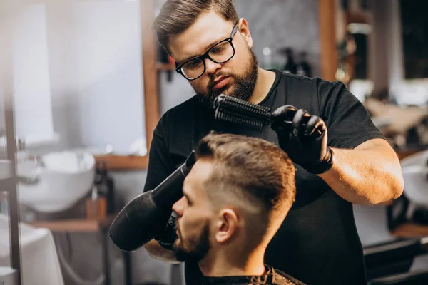 Handsome man at a barber shop styling hair