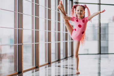 Stüdyoda jimnastik yapan şirin küçük kız.