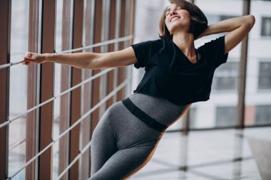 Spor salonunda egzersiz yapan genç bir kadın.