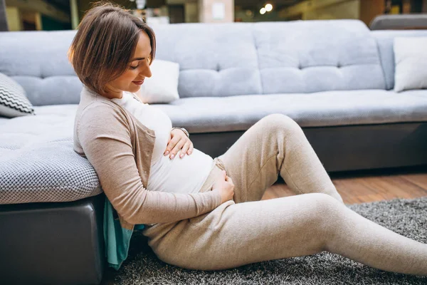Ung Gravid Kvinna Hemma Vid Soffan Håller Magen — Stockfoto
