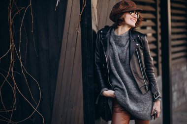 Caddenin dışında deri ceketli güzel bir kadın var.