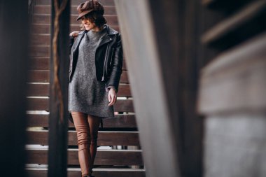 Caddenin dışında deri ceketli güzel bir kadın var.