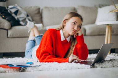 Kız evde bilgisayar başında çalışıyor.