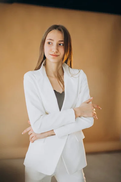 Young business woman in white suit at the studio