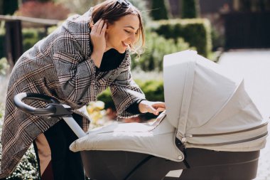 genç anne ile bebek arabası Park yürüme