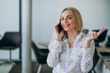 Ofiste telefon kullanan bir iş kadını.