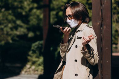 Yüz koruma maskeli genç bir kadın.