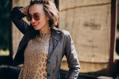 Dışarıda poz veren ceketli genç kadın.