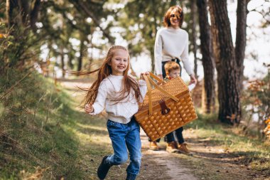 Ormanda pikniğe giden kızı ve oğlu olan genç bir anne.