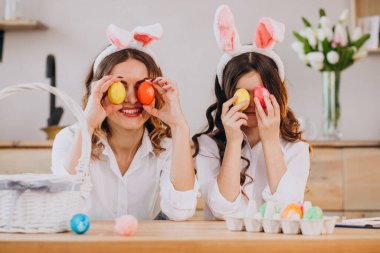 Anne ve kızı Paskalya için yumurta boyuyor.