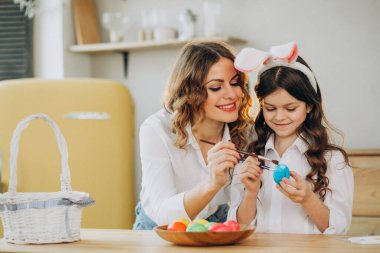 Anne ve kızı Paskalya için yumurta boyuyor.