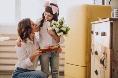 Anneler Günü 'nde annesine çiçeklerle selam veren küçük kız.