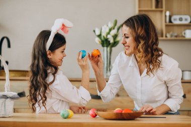 Anne ve kızı Paskalya için yumurta boyuyor.