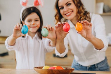 Anne ve kızı Paskalya için yumurta boyuyor.