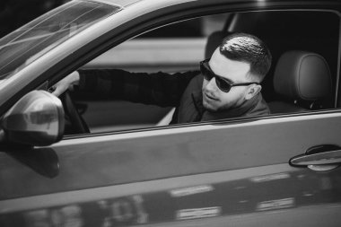 Arabada oturan yakışıklı adamın portresi.