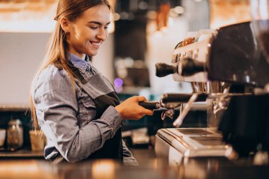 Kahve makinesinde kahve yapan bayan barista.