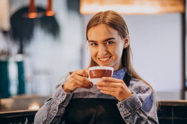 Kahve dükkanında kahve içen bayan barista.