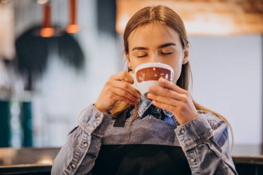 Kahve dükkanında kahve içen bayan barista.