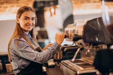 Kahve makinesinde kahve yapan bayan barista.