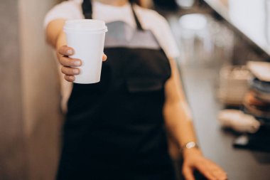 Elinde karton kahve fincanı tutan bayan barista.