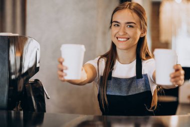 Female barista giving coffee in cardboard cups