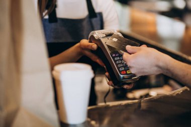 Kahve dükkanında kredi kartıyla ödeme yapan müşteri.
