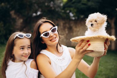 Anne ve kızı arka bahçede köpek maşasıyla birlikte.