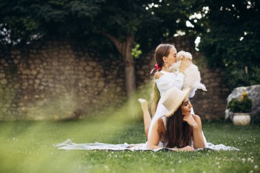 Anne ve kızı arka bahçede köpek maşasıyla birlikte.