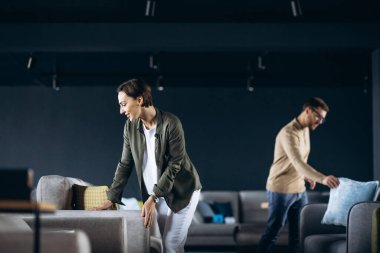 Çift mobilya dükkanında kanepe ve yastık seçiyor.