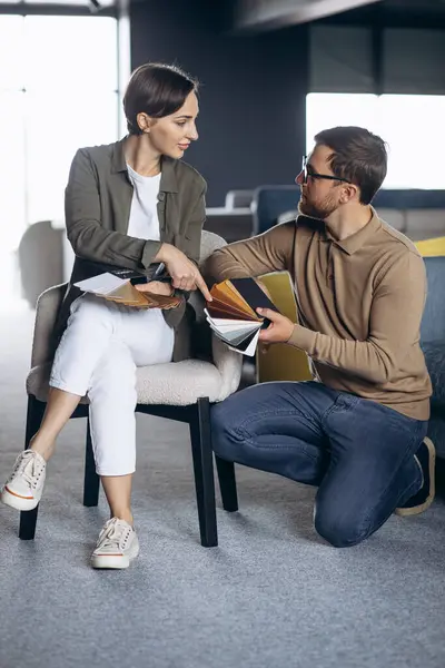 Man and woman choosing chair in furniture store