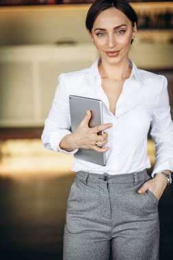 Kafede elinde tablet tutan bir iş kadını.