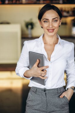 Kafede elinde tablet tutan bir iş kadını.
