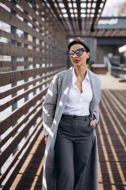 Sokakta yürüyen gri paltolu kadın portresi